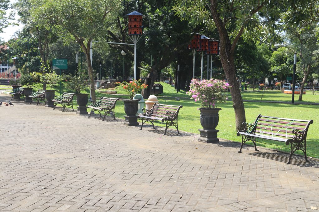 Penutupan kursi taman dengan tali rafia untuk mencegah pengunjung duduk di taman